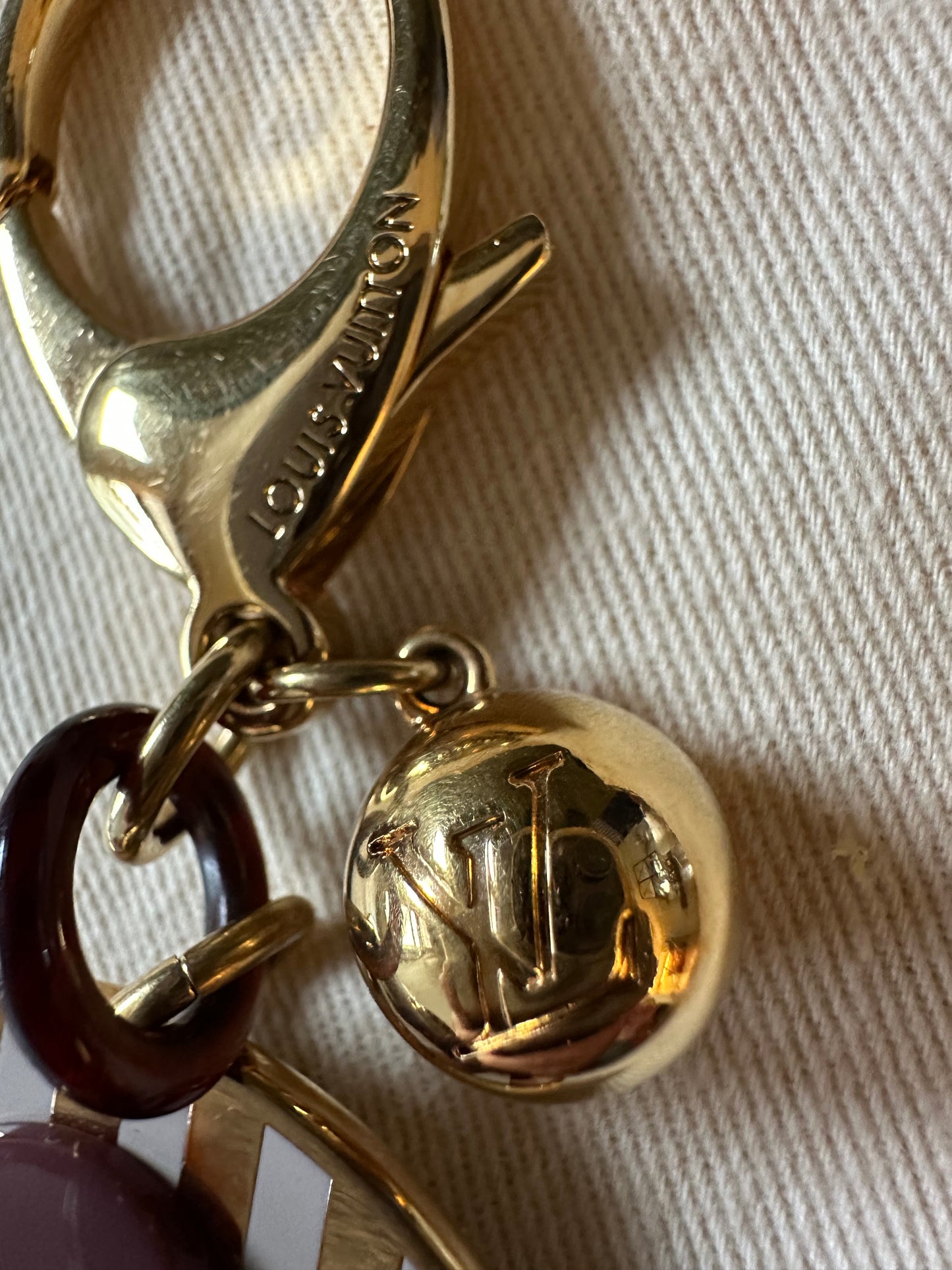 Louis Vuitton Idylle Blossom Bag Charm: in white, gold & plum.